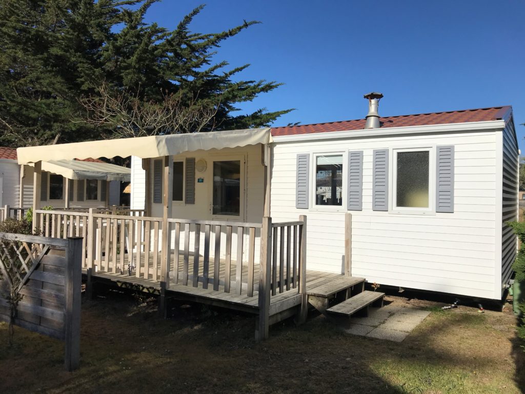 Mobil-home blanc avec terrasse en bois