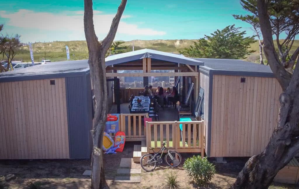 Maison en bois avec patio, vélo devant.