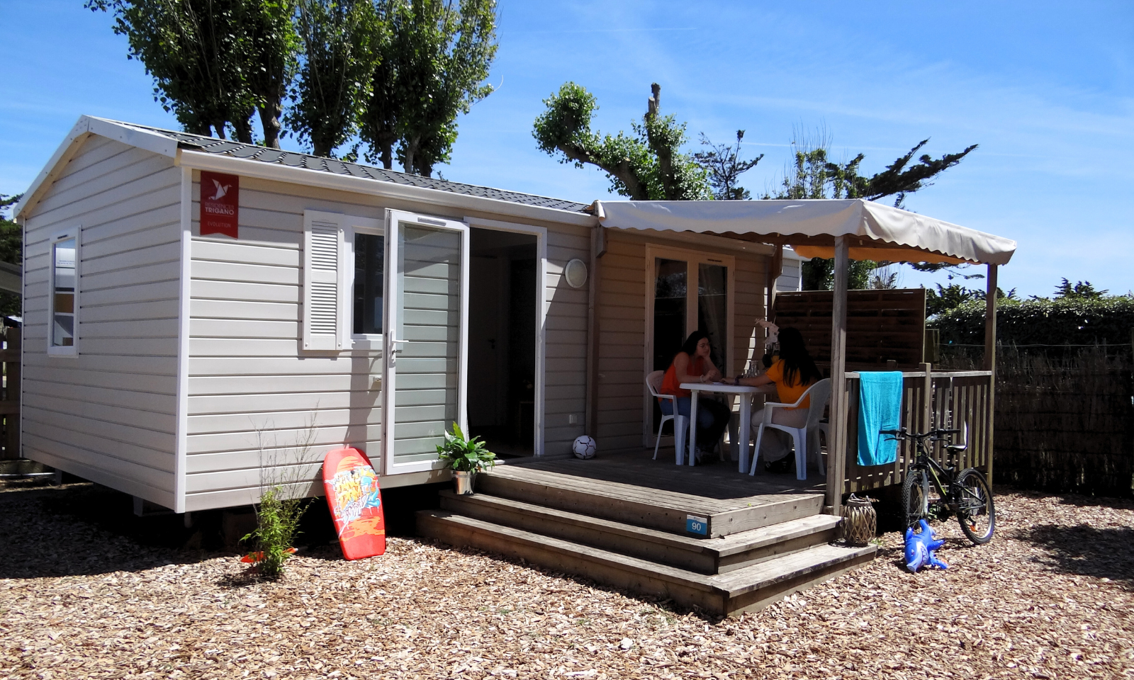 Mobil-home avec terrasse et personnes assises
