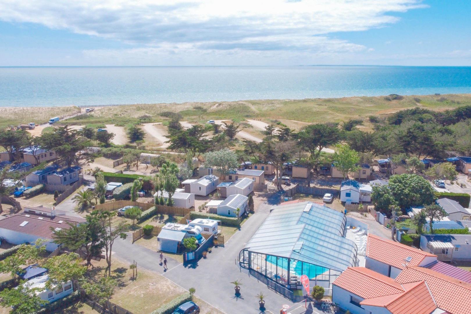 Vue aérienne camping avec piscine et plage