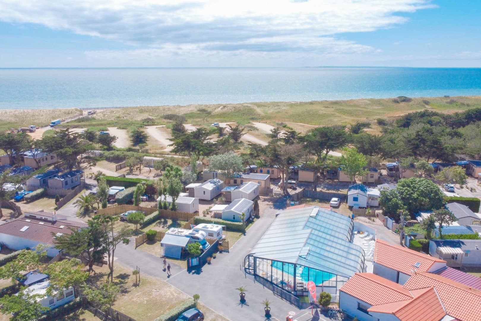 Vue aérienne camping avec piscine et plage
