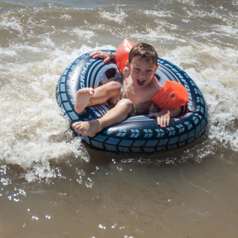 Enfant joyeux sur une bouée dans l'eau