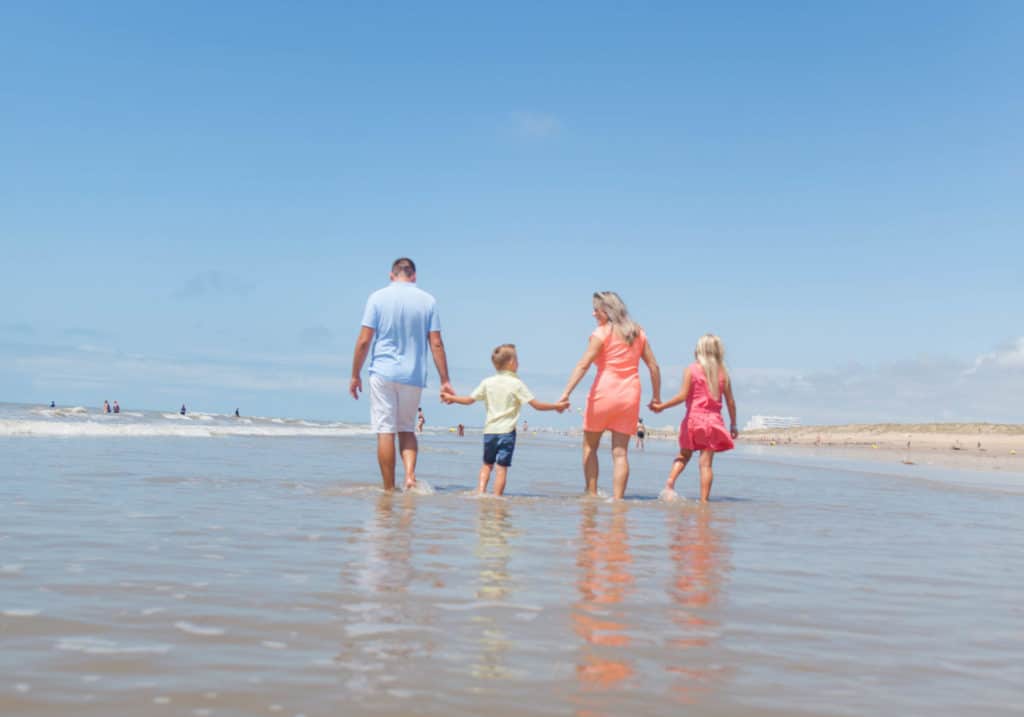Famille marchant sur la plage ensoleillée