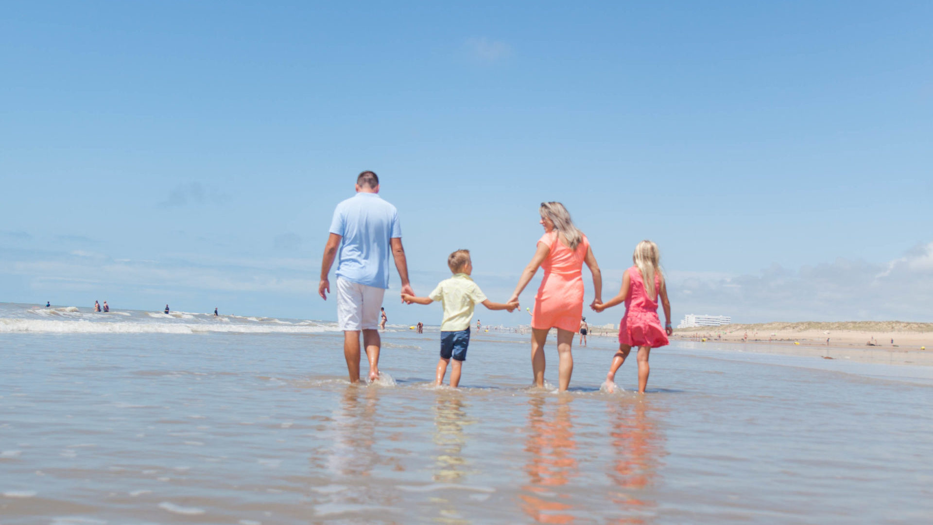 Famille marchant sur la plage ensoleillée