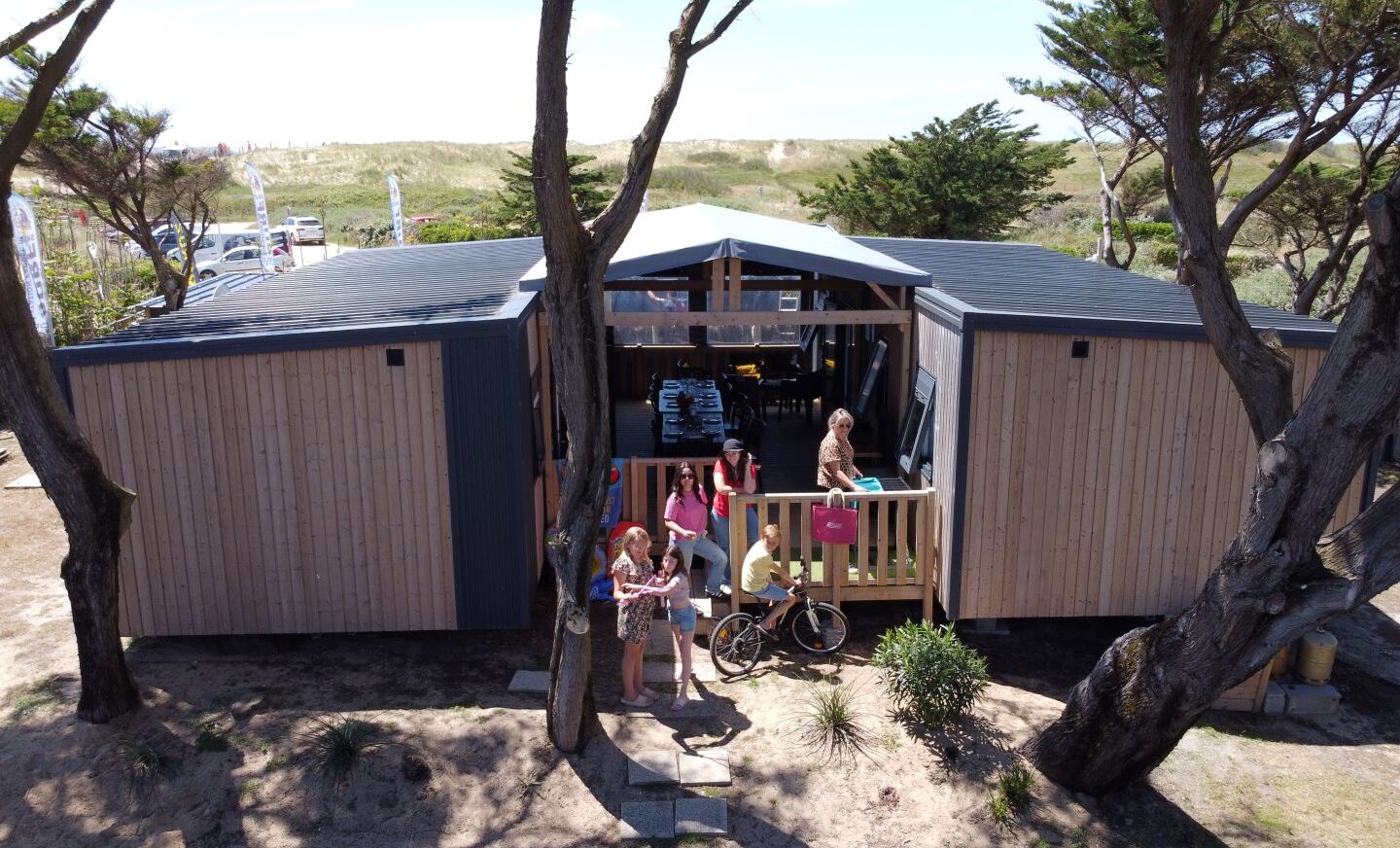 Pavillon en bois avec arbres et personnes dehors.